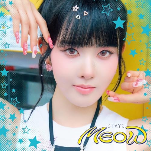 Close-up of STAYC member with star and heart hair clips, blue background.