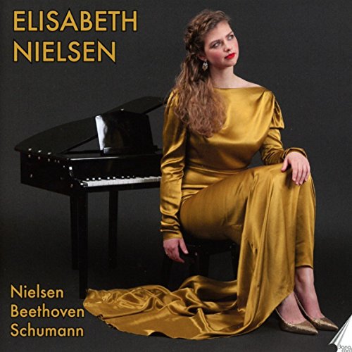 Elisabeth Nielsen in gold dress seated at a grand piano.