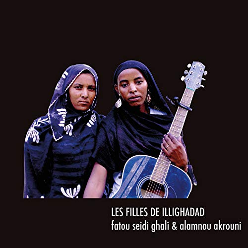 Two women with headscarves and a guitar on a dark background.