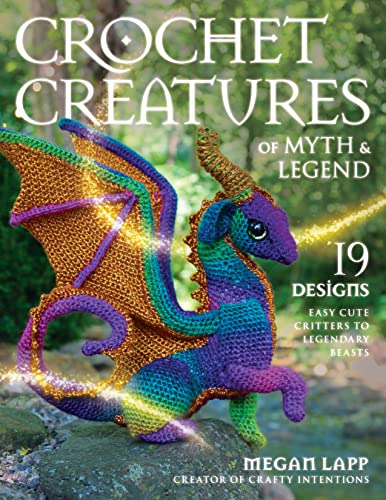 Crocheted dragon with rainbow colors and sparkles on a rock outdoors.