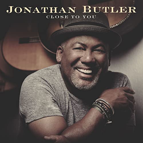 CD cover featuring smiling musician Jonathan Butler with guitars in background.