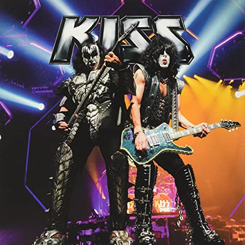 Kiss band members in stage makeup playing guitars with bright lights.
