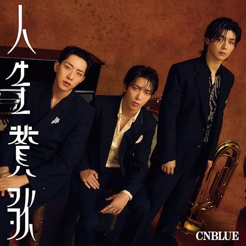CNBLUE band members in suits with a piano and brass instrument.