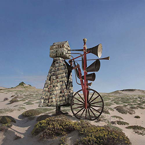Figure in patterned cloak with large red, vintage megaphone structure.