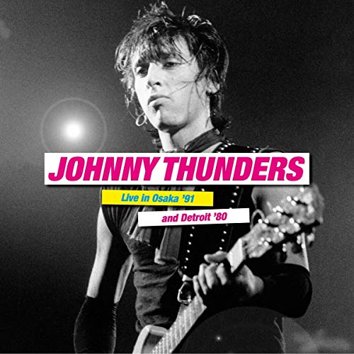 Black and white photo of Johnny Thunders playing guitar onstage.
