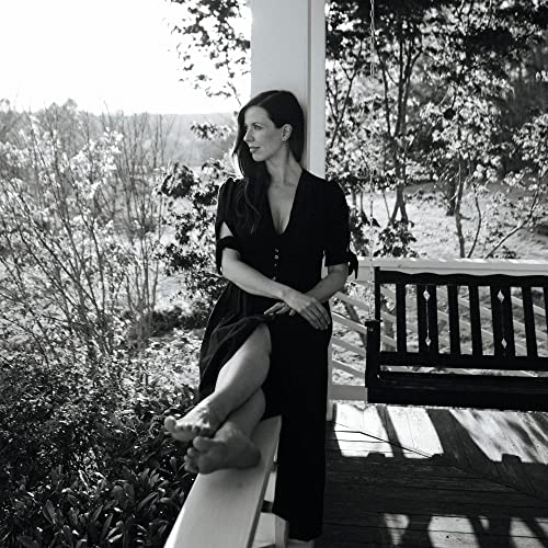 Black and white photo of a woman on a porch swing.