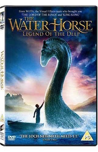 A boy in a small boat reaches toward a large sea creature in water.