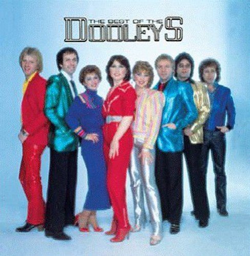 The Dooleys band members posing in colorful outfits against a light blue background.
