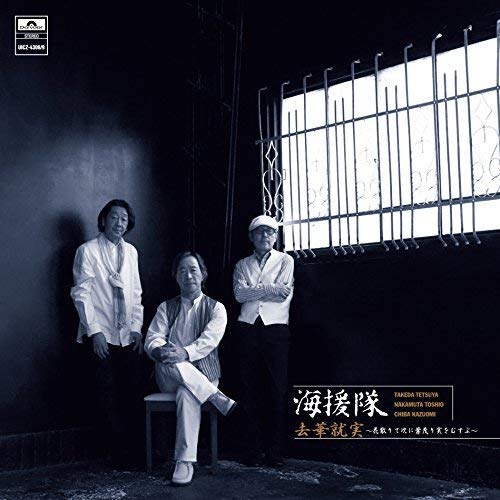 CD cover with three men in light clothing standing near bars.