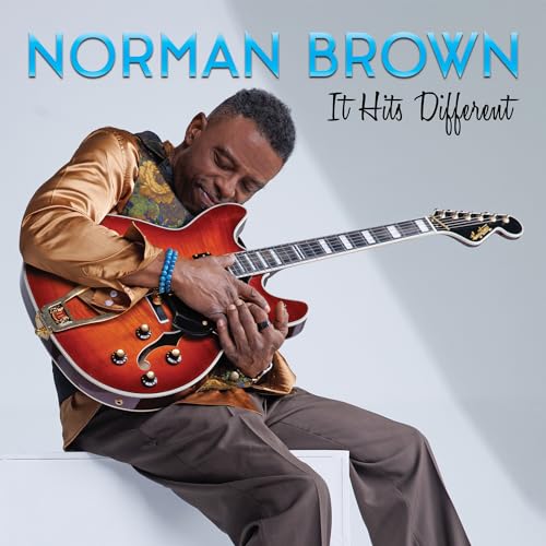 Norman Brown playing a red electric guitar, album cover art.