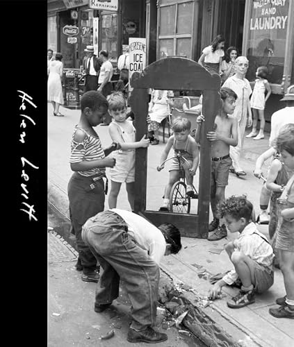 Black and white photo of children playing on a city street with a mirror.