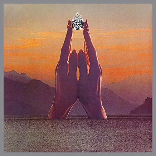 Hands holding a sparkling crystal over a landscape, album cover art.