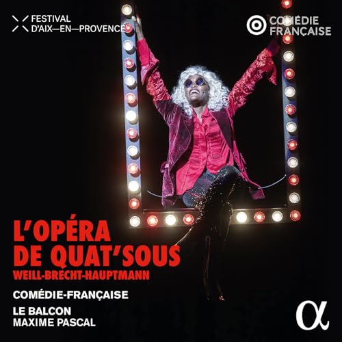 Performer in a red jacket poses dramatically before a lit marquee.