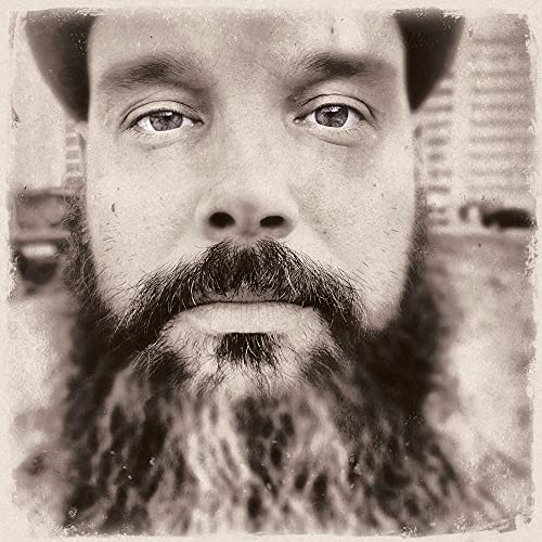 Sepia-toned portrait of a bearded man, close-up, vinyl record cover.