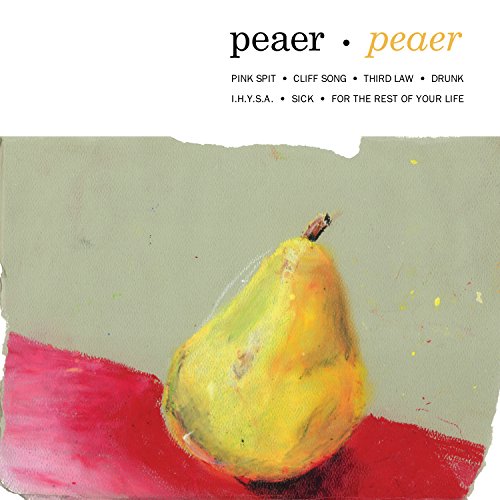 A yellow pear sits on a red surface against a muted green background.
