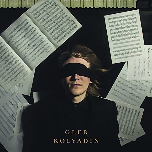 Blindfolded man surrounded by sheet music, album cover for Gleb Kolyadin.