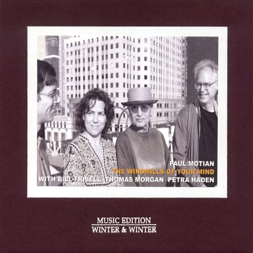 CD cover featuring four people in front of a city building.