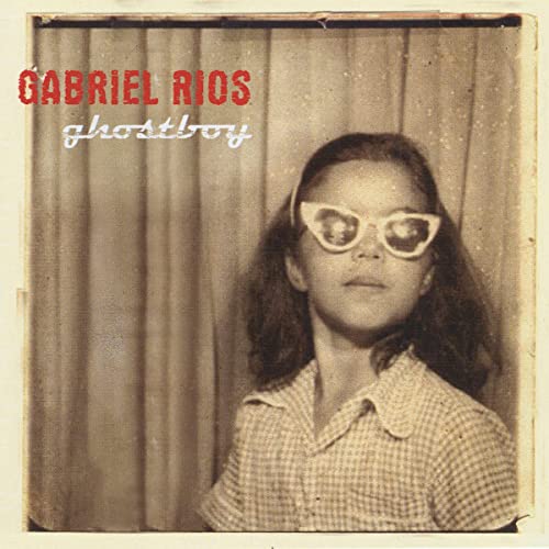 Sepia-toned album cover featuring a young boy with cat-eye glasses.