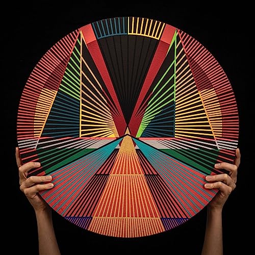 Colorful geometric vinyl record held by two hands against a black background.