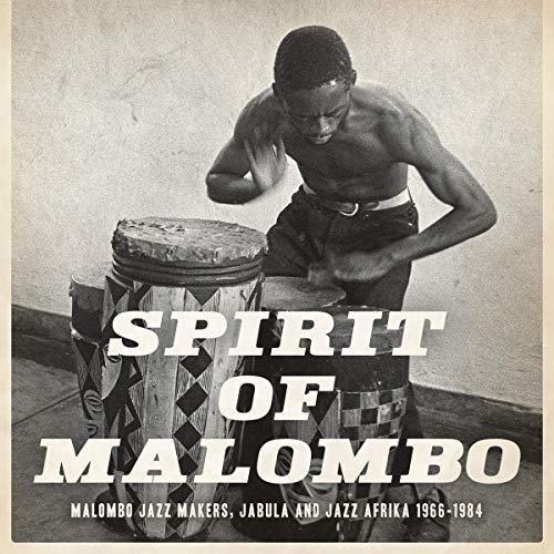 Black and white photo of a drummer with a large drum, album cover.