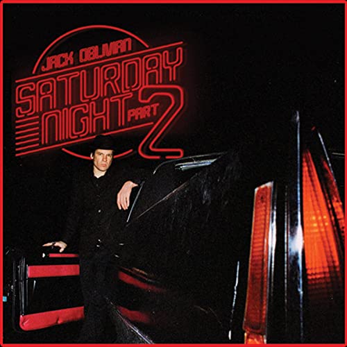 Man in black suit leaning against a car under red neon album title text.