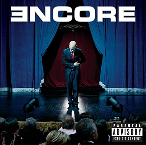 Eminem album cover: man in suit on stage with audience.