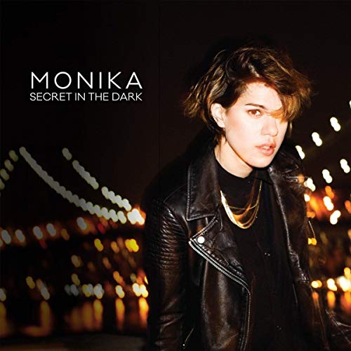 Album cover for Monika’s “Secret In The Dark” featuring a woman in a leather jacket.