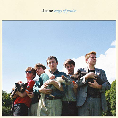 Five young men holding piglets against a bright blue sky.