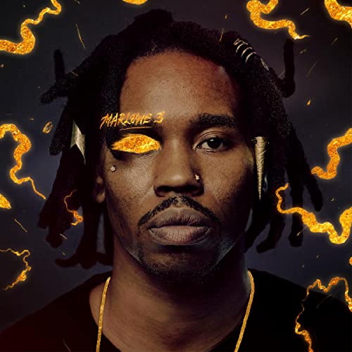 Close-up portrait of a Black man with dreadlocks, gold accents, and intense gaze.