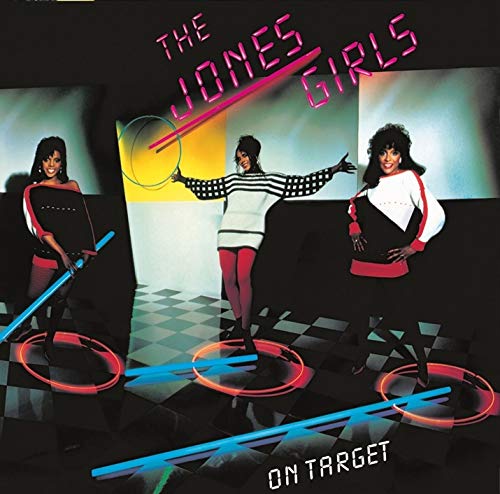 The Jones Girls standing on a checkered floor with neon light rings and text.