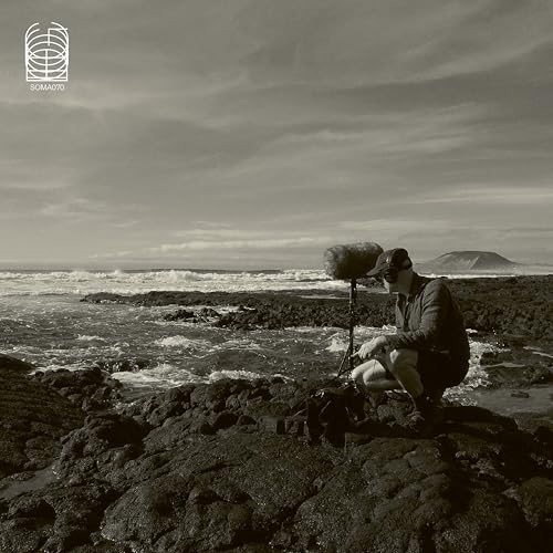 Black and white album cover featuring a man with recording equipment by the sea.