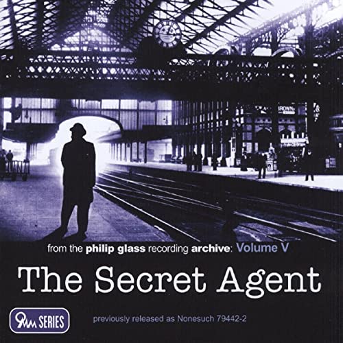 CD cover: shadowy figure in a train station, title “The Secret Agent”.