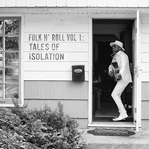 Black and white photo of a musician standing in a doorway.