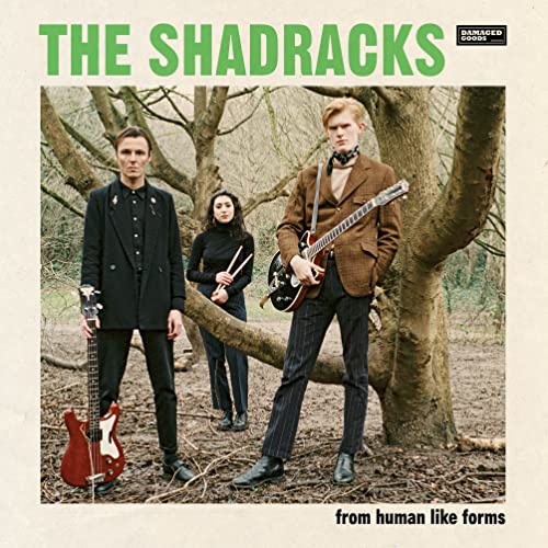 Record cover featuring three people with guitars in a wooded area.