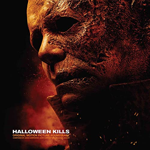 Close-up of Michael Myers’ weathered mask against a fiery, dark background.