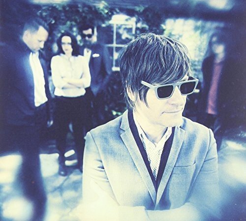 CD cover featuring a group of people in suits, blurred background.