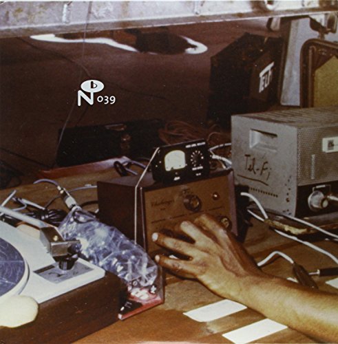 Vintage audio equipment and a hand on a wooden surface.