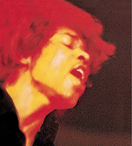 Close-up portrait of Jimi Hendrix with red and yellow lighting against dark background.