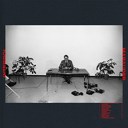 Black and white album cover featuring a man at a table with recording equipment.