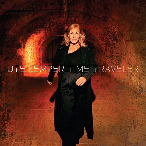Ute Lemper album cover, woman in black coat walking in tunnel.