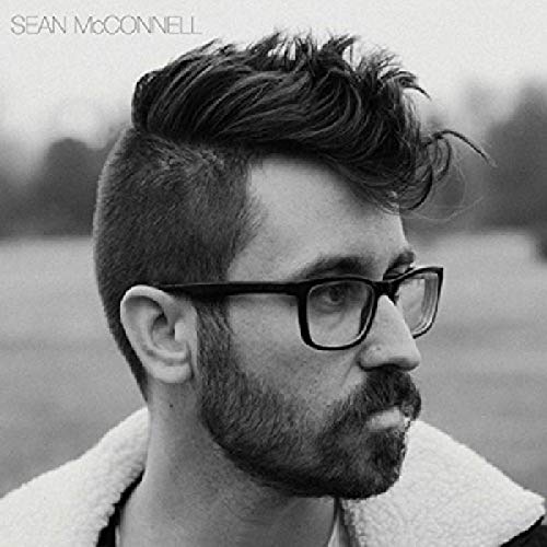 Black and white portrait of Sean McConnell with beard and glasses.