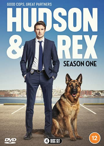 A man in a suit and a German Shepherd dog standing outdoors.