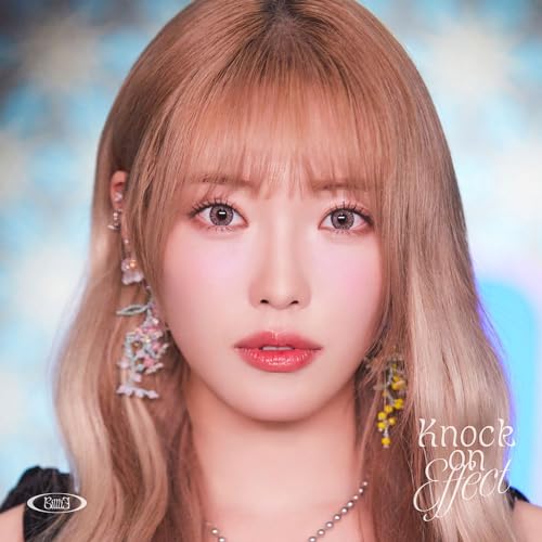 Close-up portrait of a young woman with long blonde hair and delicate earrings.