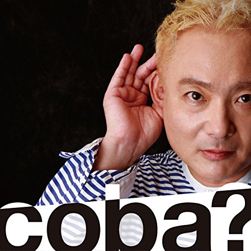 A man with blonde hair holds his hand to his ear against a black background.