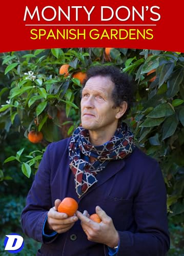 Monty Don wearing a patterned scarf and holding oranges in front of an orange tree.