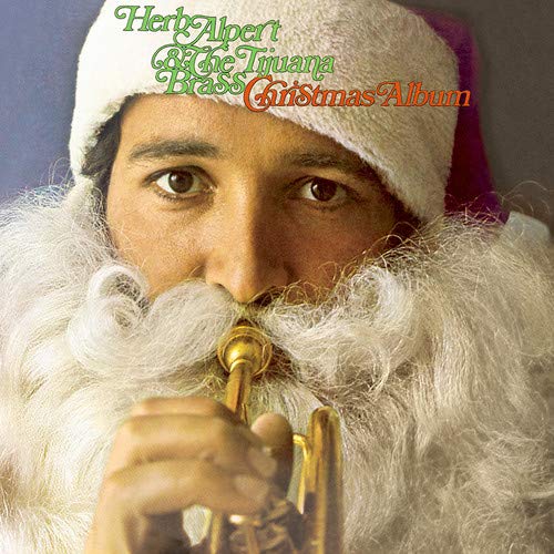 Herb Alpert in a Santa hat playing a golden trumpet album cover.