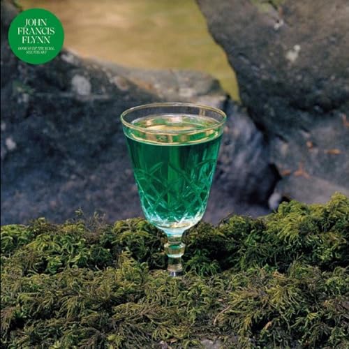 CD cover with a green glass of liquid against a rocky, mossy background.