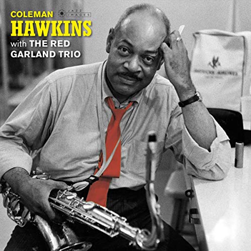 Black and white portrait of Coleman Hawkins holding a saxophone, wearing a red tie.