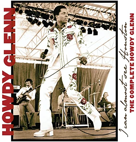 Black and white photo of Howdy Glenn performing on stage with musicians.