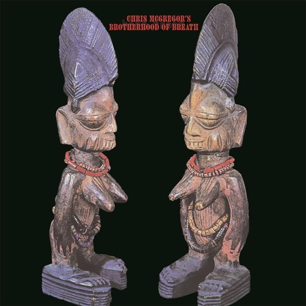 Album cover featuring two carved wooden figures against a black background.